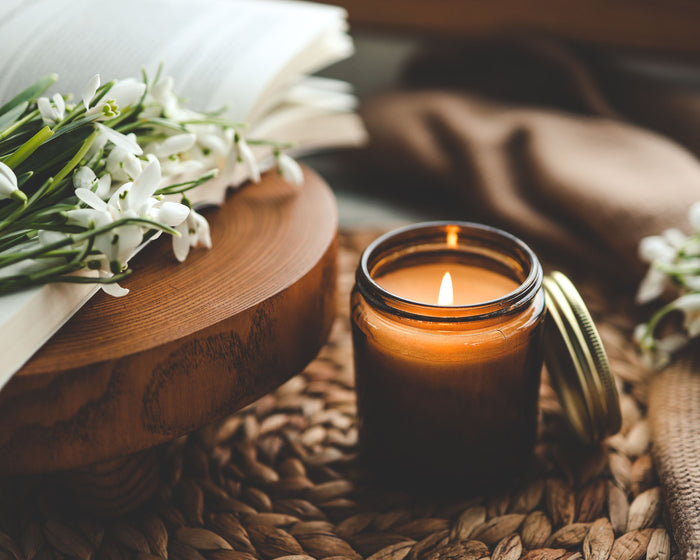 aromatherapy candle next to white flowers